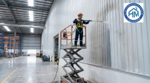 Kỹ thuật viên HOAMYCARE sử dụng xe nâng người vệ sinh vách tôn và mái tôn nhà xưởng tại Hà Nội